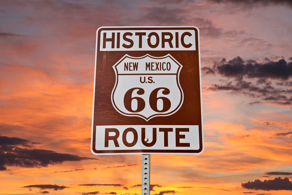 Historic Route 66 New Mexico sign with sunset sky.